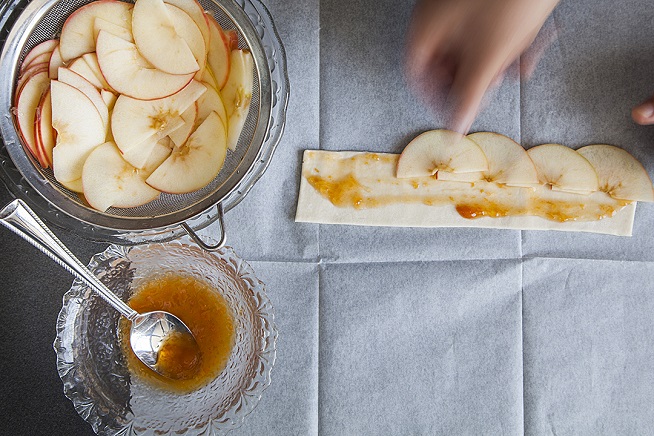 מניחים שכבה חופפת של פרוסות תפוחים לאורך הרצועה. צילום: אסף אמברם